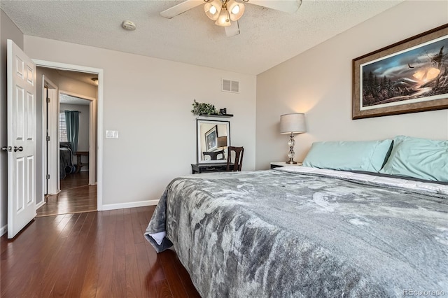 bedroom featuring ceiling fan, dark hardwood / wood-style floors, and a textured ceiling