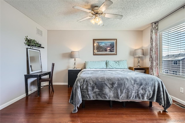 bedroom with a textured ceiling, ceiling fan, and dark hardwood / wood-style floors