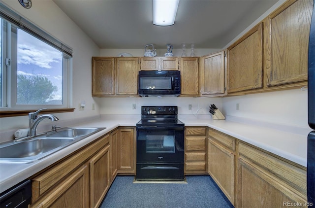 4987 Fabray Ln, Colorado Springs, CO 80922 - kitchen featuring black appliances, a sink, light countertops, dark carpet, and brown cabinets