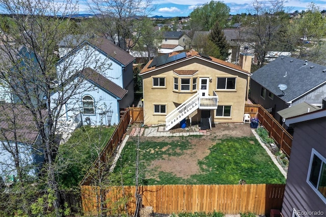 4987 Fabray Ln, Colorado Springs, CO 80922 - back of house with stairs, a chimney, stucco siding, a residential view, and solar panels