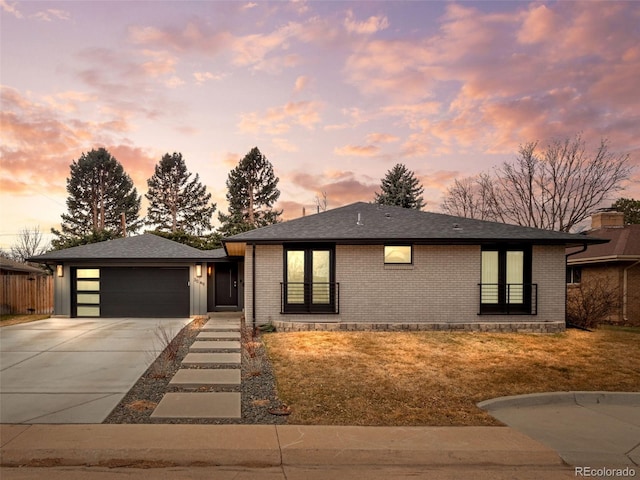 view of front of house with concrete driveway, brick siding, an attached garage, and roof with shingles