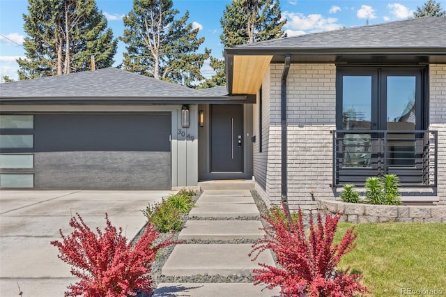 3049 S Vine St, Denver, CO 80210 - view of front facade featuring brick siding, driveway, an attached garage, and a shingled roof