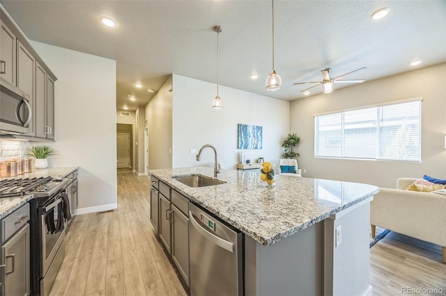 12574 Lake View St, Longmont, CO 80504 - kitchen with a sink, appliances with stainless steel finishes, open floor plan, gray cabinets, and recessed lighting
