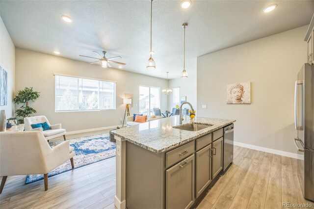 12574 Lake View St, Longmont, CO 80504 - kitchen featuring a sink, stainless steel appliances, gray cabinets, a ceiling fan, and light wood-style floors