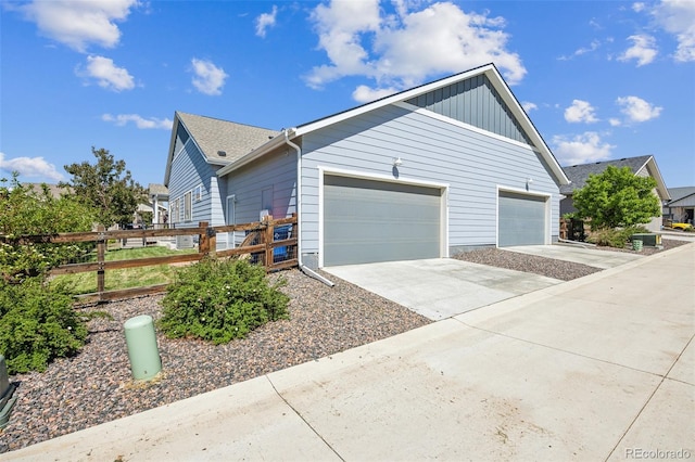 12574 Lake View St, Longmont, CO 80504 - view of side of property with a garage, fence, concrete driveway, and board and batten siding