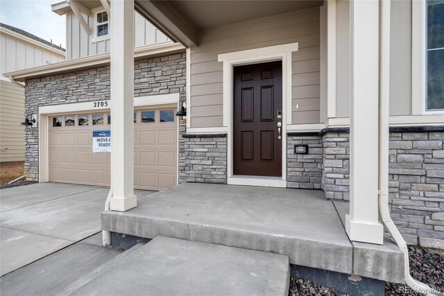 2705 73rd Avenue Ct, Greeley, CO 80634 - property entrance with stone siding, driveway, and a porch