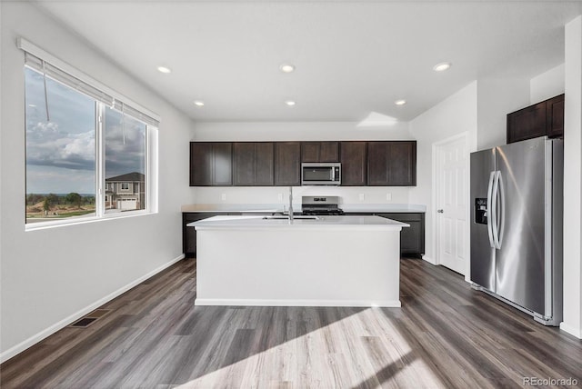 2705 73rd Avenue Ct, Greeley, CO 80634 - kitchen with stainless steel appliances, dark brown cabinetry, dark wood-style flooring, a kitchen island with sink, and recessed lighting
