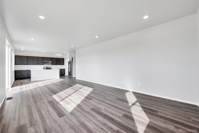 2705 73rd Avenue Ct, Greeley, CO 80634 - unfurnished living room featuring wood finished floors, baseboards, and recessed lighting