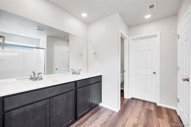 2705 73rd Avenue Ct, Greeley, CO 80634 - full bathroom with toilet, double vanity, wood finished floors, and baseboards