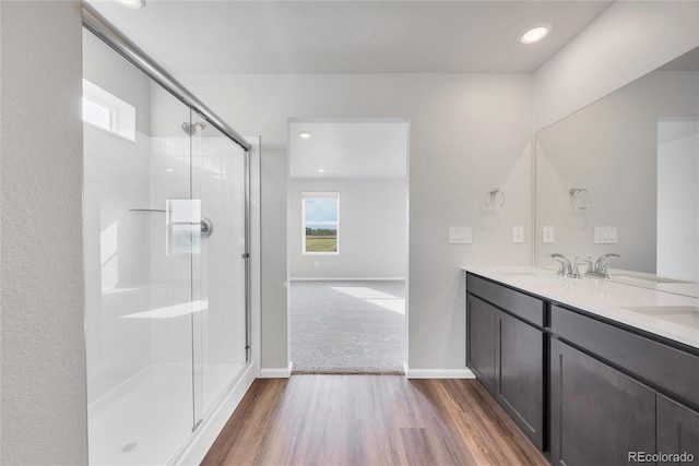 2705 73rd Avenue Ct, Greeley, CO 80634 - full bathroom with wood finished floors, an enclosed shower, double vanity, baseboards, and recessed lighting