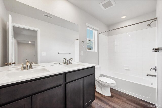 2705 73rd Avenue Ct, Greeley, CO 80634 - full bath featuring double vanity, toilet, wood finished floors, and bathing tub / shower combination
