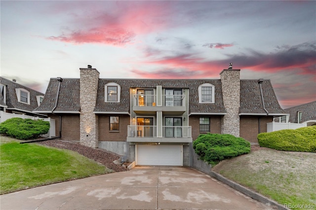 15491 E Wyoming Dr Unit A, Aurora, CO 80017 - view of front of home with a balcony, a garage, concrete driveway, and a chimney