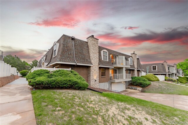 15491 E Wyoming Dr Unit A, Aurora, CO 80017 - view of property exterior featuring a balcony, a garage, mansard roof, a chimney, and a shingled roof