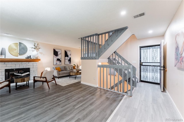 15491 E Wyoming Dr Unit A, Aurora, CO 80017 - living area featuring wood finished floors, baseboards, a fireplace, and stairs