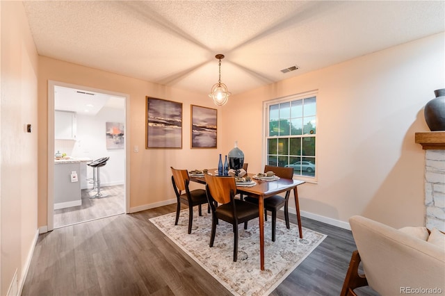 15491 E Wyoming Dr Unit A, Aurora, CO 80017 - dining space featuring dark wood-type flooring, baseboards, and a textured ceiling