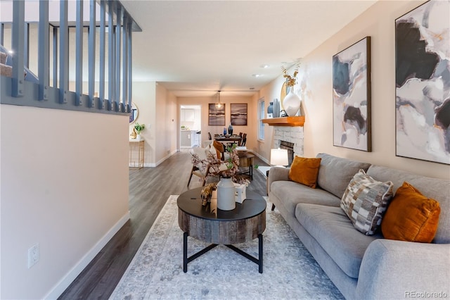 15491 E Wyoming Dr Unit A, Aurora, CO 80017 - living room featuring baseboards, wood finished floors, and a stone fireplace