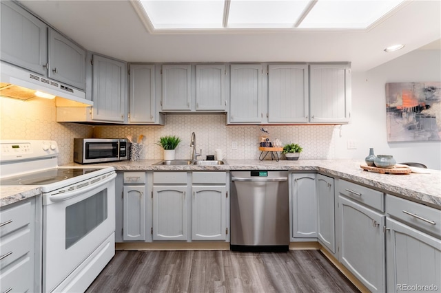 15491 E Wyoming Dr Unit A, Aurora, CO 80017 - kitchen featuring stainless steel appliances, a sink, under cabinet range hood, dark wood-style floors, and tasteful backsplash