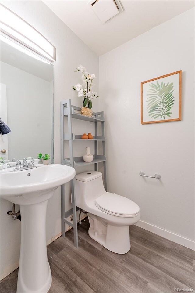 15491 E Wyoming Dr Unit A, Aurora, CO 80017 - half bath with wood finished floors, toilet, a sink, and baseboards