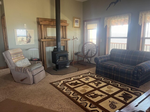 carpeted living room with a wood stove