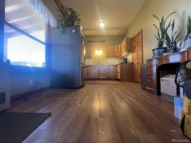 kitchen with dark hardwood / wood-style flooring, stainless steel fridge, and sink