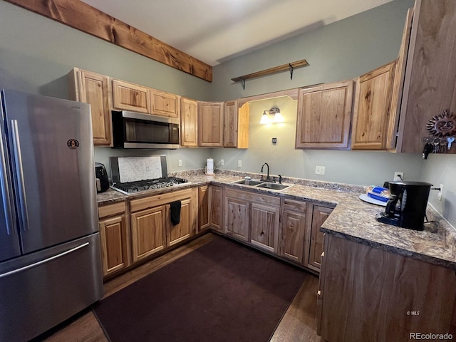 kitchen with stone counters, appliances with stainless steel finishes, dark hardwood / wood-style floors, and sink