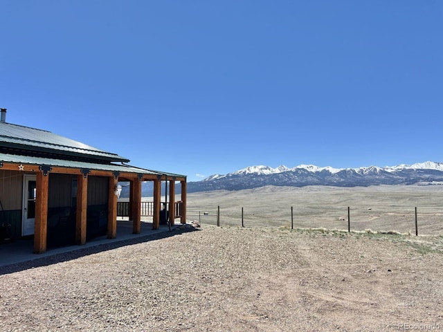 view of yard featuring a mountain view, a rural view, and an outdoor structure