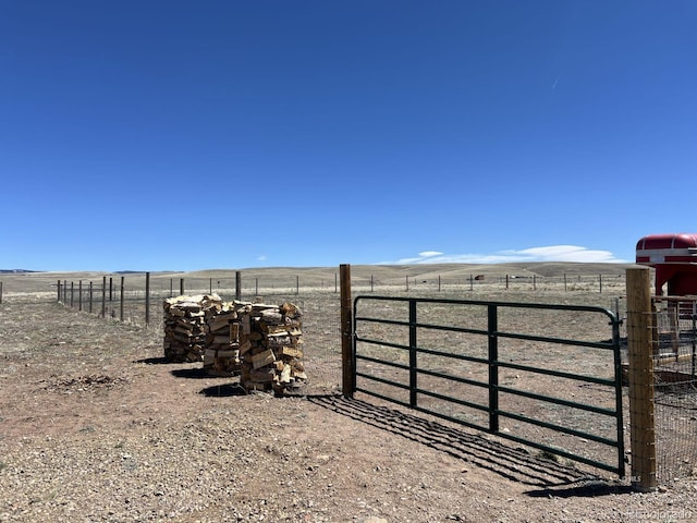 view of gate with a rural view