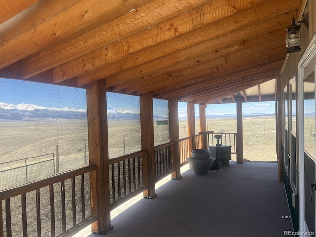 sunroom featuring lofted ceiling and a rural view