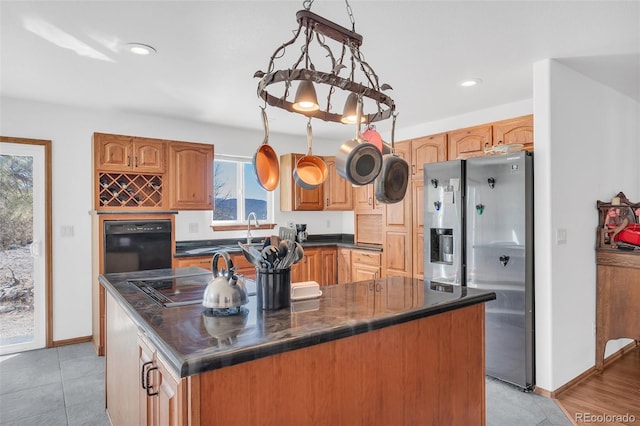 kitchen with pendant lighting, a center island, stainless steel appliances, and light tile patterned floors