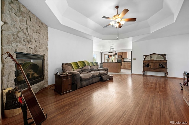 living room with hardwood / wood-style floors, a fireplace, and a raised ceiling