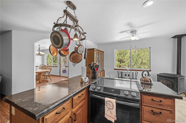 kitchen featuring a center island, stainless steel electric stove, a healthy amount of sunlight, and light hardwood / wood-style floors