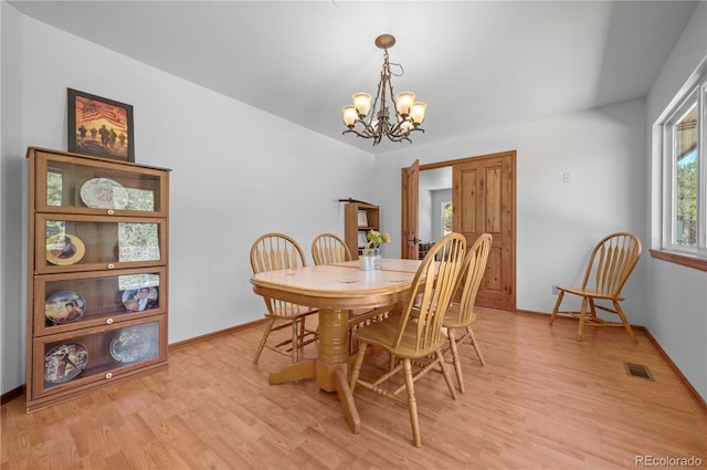 dining room featuring a notable chandelier and light wood-type flooring