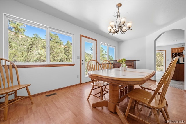 dining space featuring light hardwood / wood-style floors and a chandelier