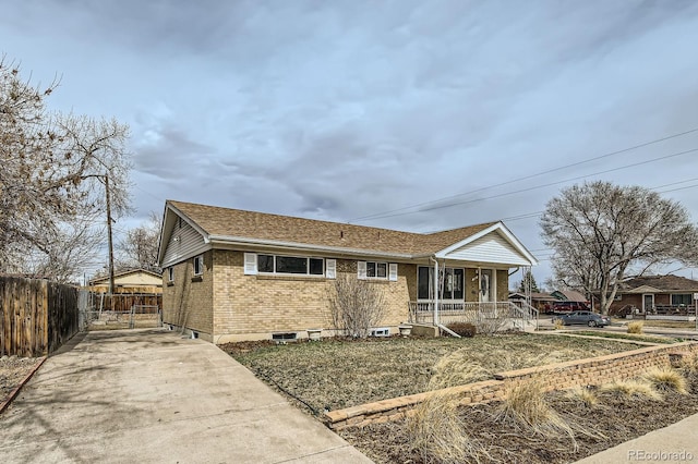 single story home featuring driveway, a porch, fence, and brick siding