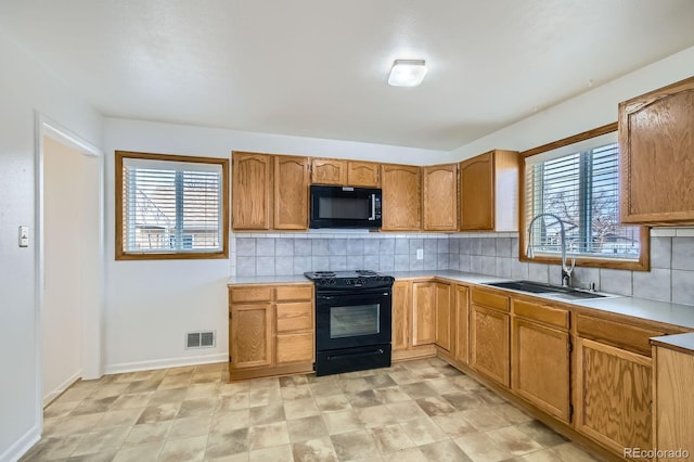 kitchen with visible vents, black appliances, a sink, and a healthy amount of sunlight