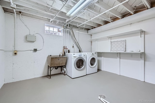washroom featuring washer and clothes dryer, laundry area, and a sink