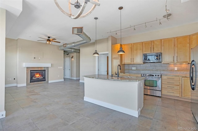 kitchen with pendant lighting, appliances with stainless steel finishes, light brown cabinets, sink, and light stone counters