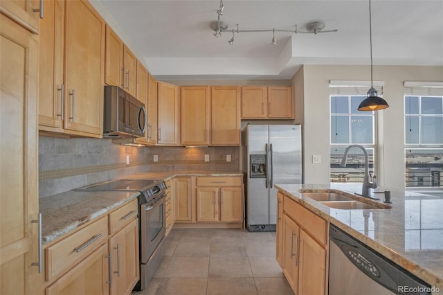 kitchen featuring pendant lighting, sink, appliances with stainless steel finishes, light brown cabinetry, and light stone counters