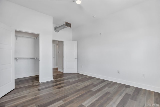 unfurnished bedroom featuring a closet and dark hardwood / wood-style floors