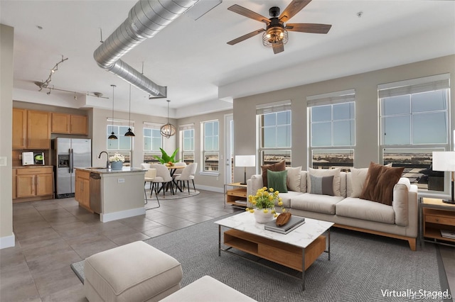 living room featuring ceiling fan, sink, and light tile patterned flooring