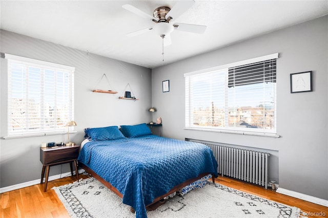 85 N Grant St Unit 30, Denver, CO 80203 - bedroom with wood finished floors, baseboards, a ceiling fan, and radiator heating unit