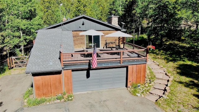 10439 Christopher Dr, Conifer, CO 80433 - view of front of property with asphalt driveway, a garage, a chimney, roof with shingles, and log siding