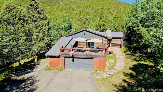 10439 Christopher Dr, Conifer, CO 80433 - view of front of property with a view of trees, driveway, a chimney, and a garage