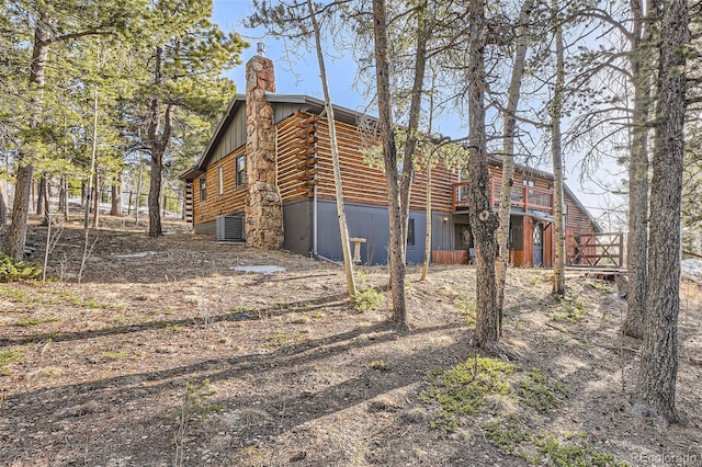 10439 Christopher Dr, Conifer, CO 80433 - view of side of home featuring log siding, a chimney, and a deck