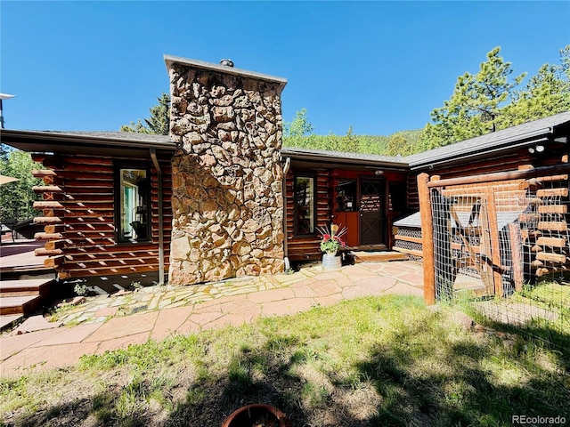 10439 Christopher Dr, Conifer, CO 80433 - back of property with a chimney and log exterior