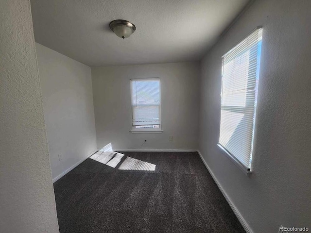 carpeted empty room with a textured ceiling