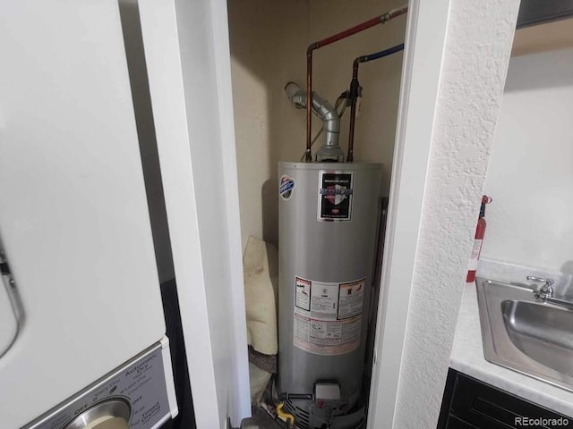 utility room featuring sink, gas water heater, and water heater