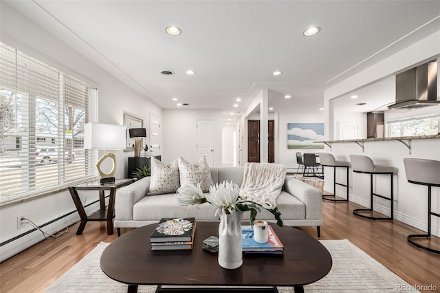 living room with visible vents, light wood-style flooring, recessed lighting, a baseboard radiator, and baseboards