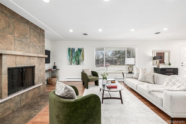 living area with recessed lighting, wood finished floors, visible vents, and a tile fireplace