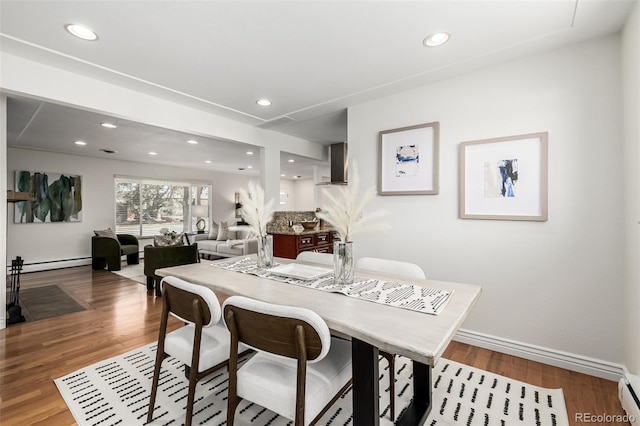 dining area with recessed lighting, wood finished floors, baseboards, and a baseboard radiator